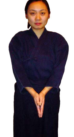 Woman in kendo uniform facing forward, demonstrating arm position.