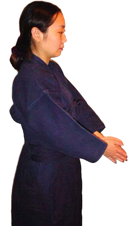 Woman in kendo uniform facing right, demonstrating arm position.